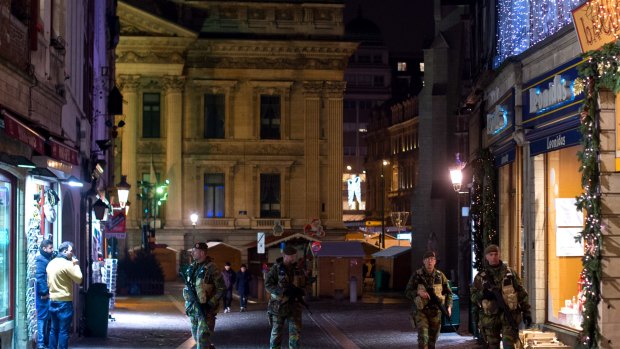 Armed soldiers patrol along Rue des Sols in Brussels on Monday.