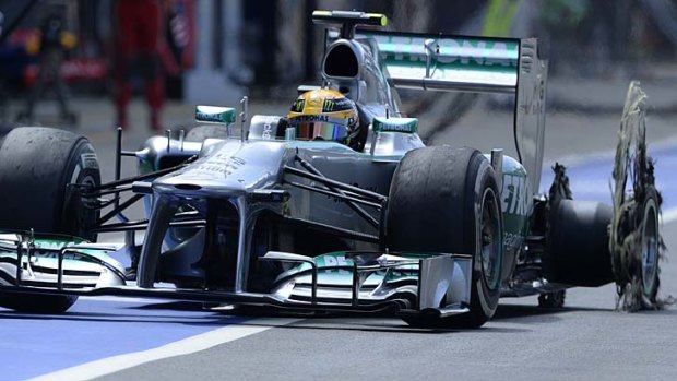 Angry: Lewis Hamilton enters the pit with a puncture.
