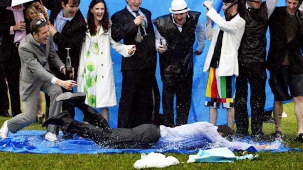 A punter makes the most of rain using a tarpaulin as a slip 'n' slide to entertain his friends.