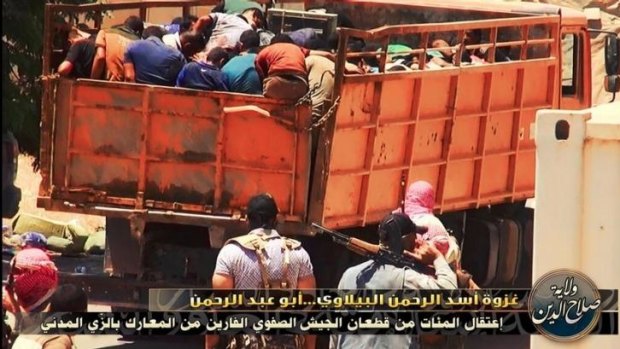 ISIL prisoners are packed into a truck and driven away.