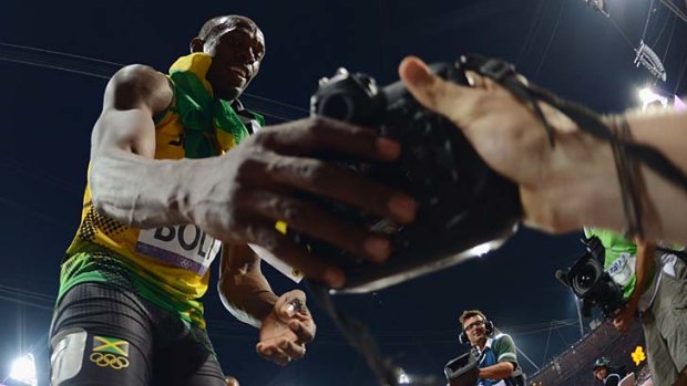 Have a go ... Usain Bolt grabs Jimmy Wixtrom's camera.