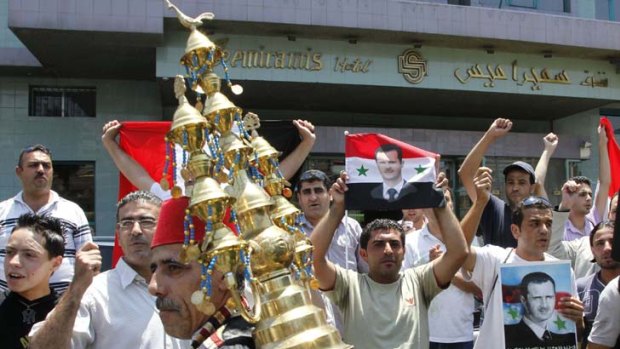 President Bashar al-Assad's supporters demonstrate outside the Damascus hotel where opposition intellectuals were meeting.