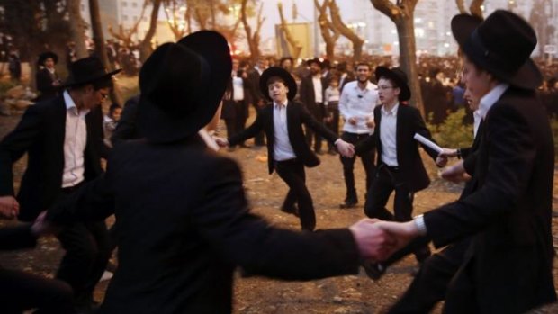 Ultra-Orthodox Jewish youths dance after a mass prayer at the Jerusalem demonstration.
