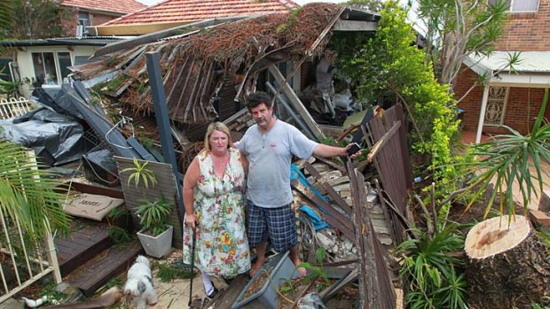Rock and Kendall Davis-Bogan, surrounded by damage caused to their house.