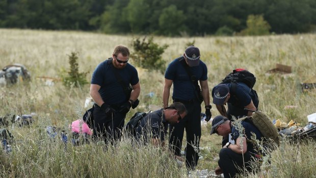Australian Federal Police officers and their Dutch counterparts collect human remains from the MH17 crash site in the self proclaimed Donetsk Republic, Ukraine on 2 August, 2014.