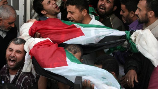 Family wiped out ...  mourners carry the bodies of children from the al-Dallu family, draped in Palestinian flags, during their funeral procession on Monday.