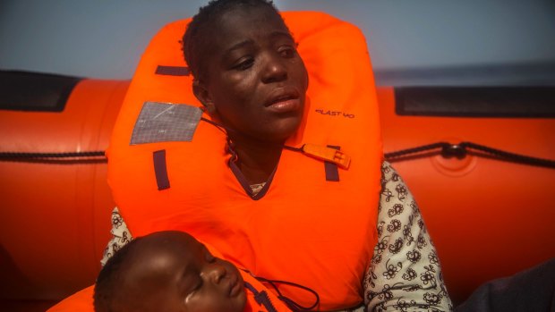 A woman from Ivory Coat holds her child after being rescued in the Mediterranean.