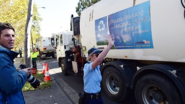 Police guide garbage trucks from Blacktown at the protest against SBS show <i>Struggle Street</i>.