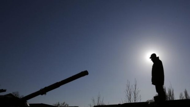 Military manoeuvres: A Russian soldier directs a tank onto a flat-bed truck near Simferopol.