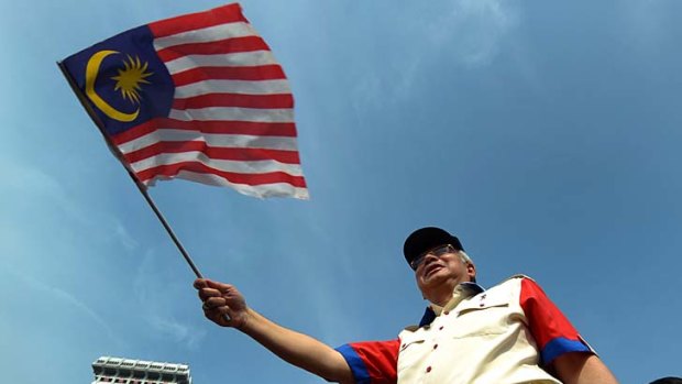 Malaysian Prime Minister Najib Razak waving a national flag.