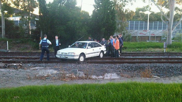 Attempts are made to push the car off tracks at East Malvern.
