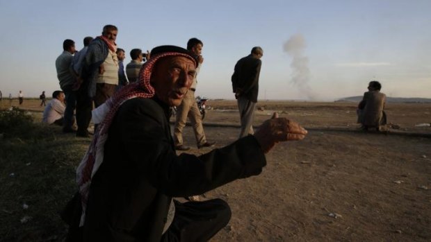 Watching brief: Turkish Kurds watch as airstrikes hit Kobane.