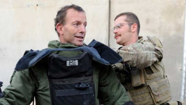Tony Abbott tries on a bomb-disposal suit at Tarin Kowt base in Afghanistan.