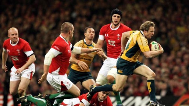 Hynes legs . . . Wallabies winger Peter Hynes bolts through the Welsh defence to set up another attack in the tour-ending victory at Millennium Stadium on Saturday.