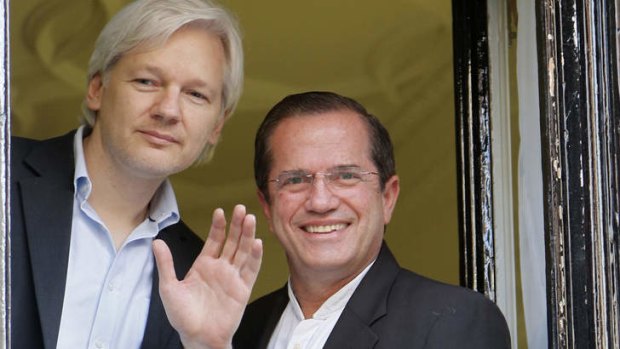 Window on the world: WikiLeaks founder Julian Assange waves to supporters with Ecuador's Foreign Affairs Minister Ricardo Patino.