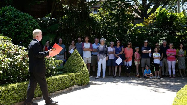 Auctioneer Peter Baldwin in front of the crowd gathered for the auction of the Roseville house.