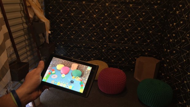 A corner full of colourful cushions comes to life with interactive virtual toys on the screen.