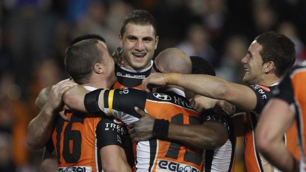 Robbie Farah celebrates with Tigers team mates after kicking the golden point field goal against the Knights.
