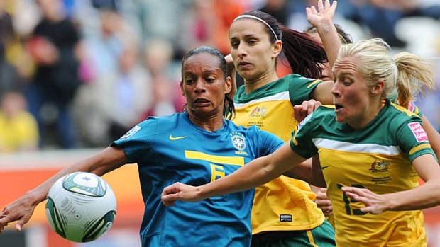 Brazil's defender Rosana fights for possession ahead of Australian midfielders Tameka Butt (R) and Servet Uzunlar.