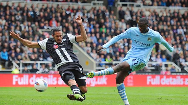 Matchwinner: Manchester City's Yaya Toure scores despite the best efforts of Newcastle's Jonas Gutierrez.