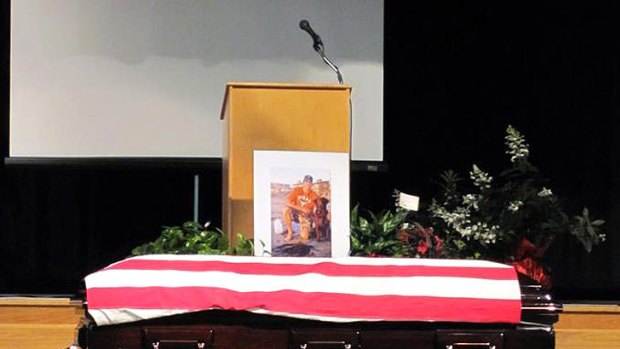 Loyal to the end ... Hawkeye lies beside the coffin of US Navy SEAL Jon Tumilson during his funeral.