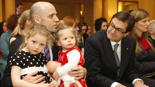 Greg Combet looks on as Mark Arbib sits with daughters Alexandra, 3, and Charlotte, 1, on his lap.