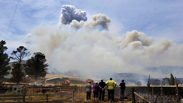 Residents and firefighters watch a bushfire on Mount Forest Road near Cooma.