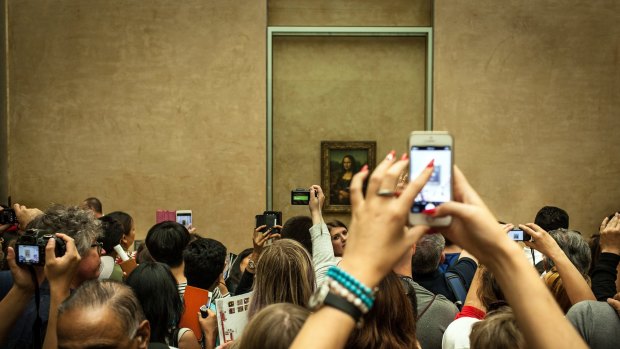 She's back there somewhere: crowds viewing the Mona Lisa at the Louvre.