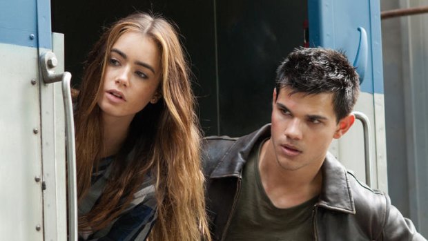 Thrill of the chase ... Taylor Lautner, on the run with Lily Collins, manages to keep his shirt on for most of his Bourne-style adventure.