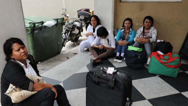 Guaranteed rest days ... newly arrived domestic helpers from Indonesia wait for their transportation to a maid agency. They will benefit from Singapore's new law.