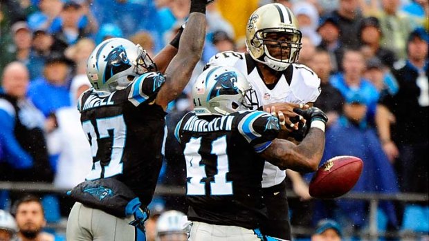 Captain Munnerlyn #41 and Quintin Mikell #27 of the Carolina Panthers break up a pass intended for Marques Colston #12 of the New Orleans Saints.