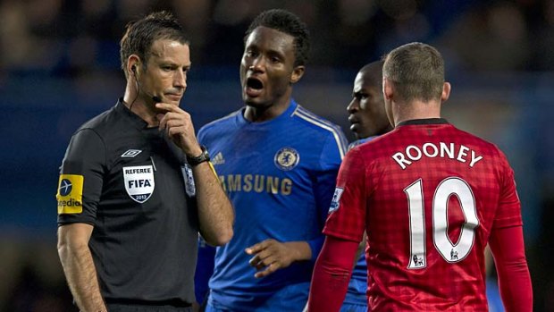 A picture taken on October 28, 2012 shows Chelsea's Nigerian midfielder John Mikel Obi (second left) talking with referee Mark Clattenburg (left) during the English Premier League football match between Chelsea and Manchester United at Stamford Bridge in London.
