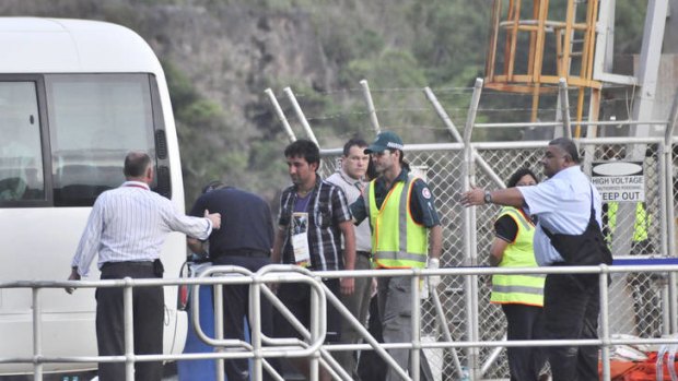 Rescued suspected asylum seekers arrive at Christmas Island after their boat capsized.