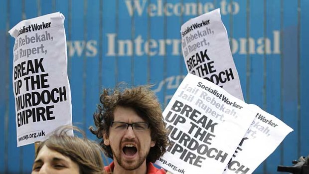 Protesters shout their opposition to the News of the World outside News International's headquarters in London.