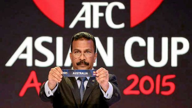 Tough draw: AFC general secretary Dato' Alex Soosay holds up the name Australia during the draw for the 2015 Asian Cup.
