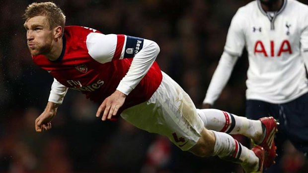 Arsenal's German defender Per Mertesacker launches himself at the ball during the match against Tottenham Hotspur.