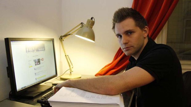 Austrian student Max Schrems sits with 1222 pages worth of his personal data that Facebook provided to him.
