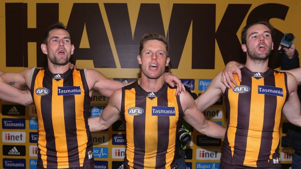 Matt Suckling (right) joins Luke Hodge and Sam Mitchell in singing the team song after the weekend win over Geelong.