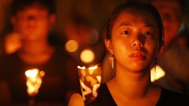 A woman holds a candle as she she joins tens of thousands of people attending a candlelight vigil at Victoria Park in Hong Kong to mark the 25th anniversary of the military crackdown on the pro-democracy movement in Beijing. 