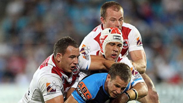 Gold Coast Titans player  William Zillman is tackled by three St George players.