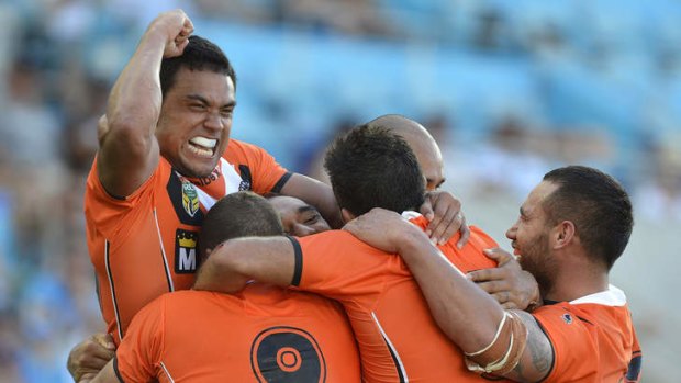 Wests Tigers' Martin Taupau celebrates with team mates after his try against the Titans.