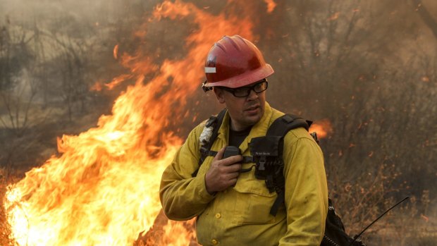 A firefighter watches a wildfire near Placenta Canyon Road in Santa Clarita. 