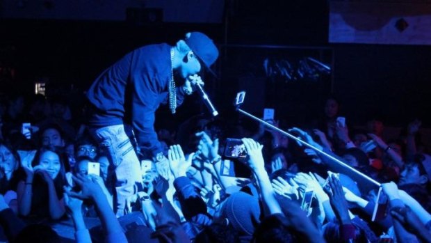 A music fan using a selfie stick at a concert in Toronto, Canada.