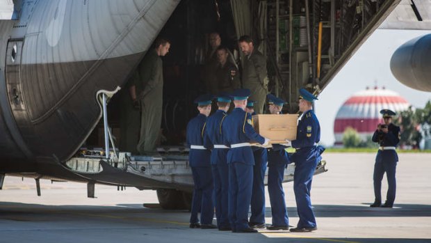 A coffin containing the body of a victim of the crash of Malaysia Airlines flight MH17 is loaded onto a plane for transport to the Netherlands.