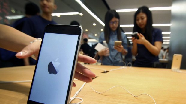 Chinese women try iPhones at a newly-opened Apple Store in Nanjing in east China's Jiangsu province. 