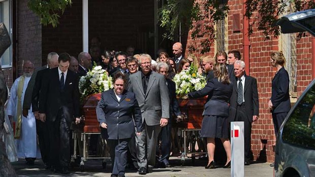 Mourners outside the church as caskets leave the funeral of Robert and Cheryl Adamson.