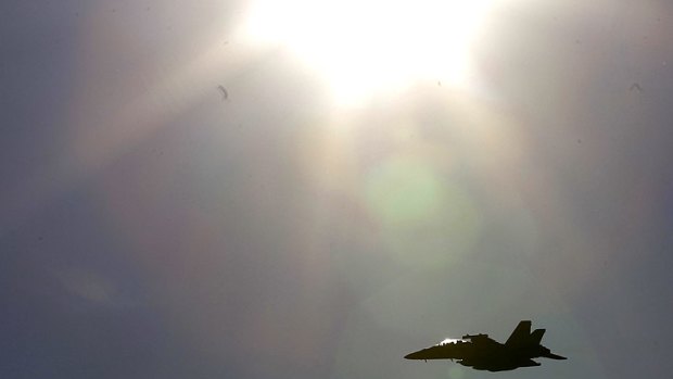 On the second day of UN-backed hostilities against Libya, an F-18 jet fighter flies over a NATO airbase in Aviano, Italy.
