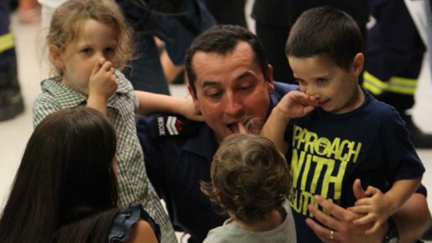 Home safe ... rescue officer Gary Wardlaw with his family.