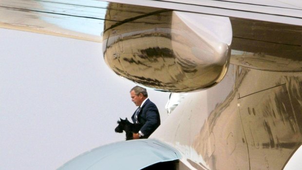 Carrying Barney, then US President George W. Bush steps down from Air Force One in 2003.