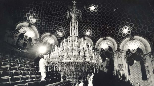 Down lights ... the chandelier at the State Theatre is carefully lowered and then cleaned in 1991.